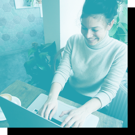 blue tinted image of woman typing on laptop